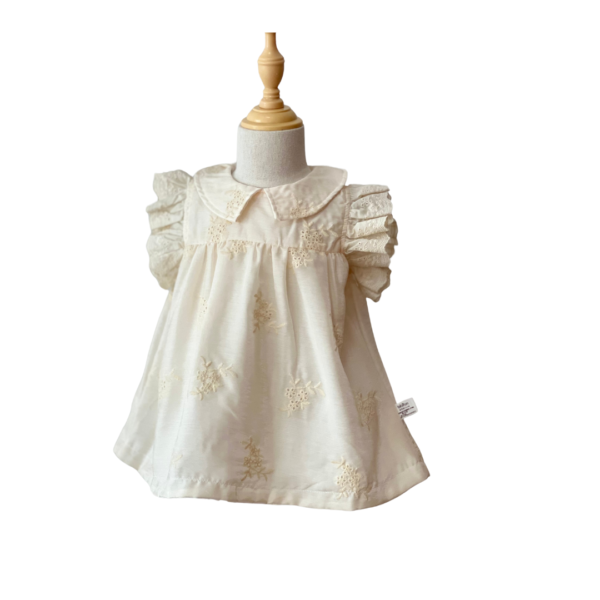 Vestido color beige con flores bordadas.